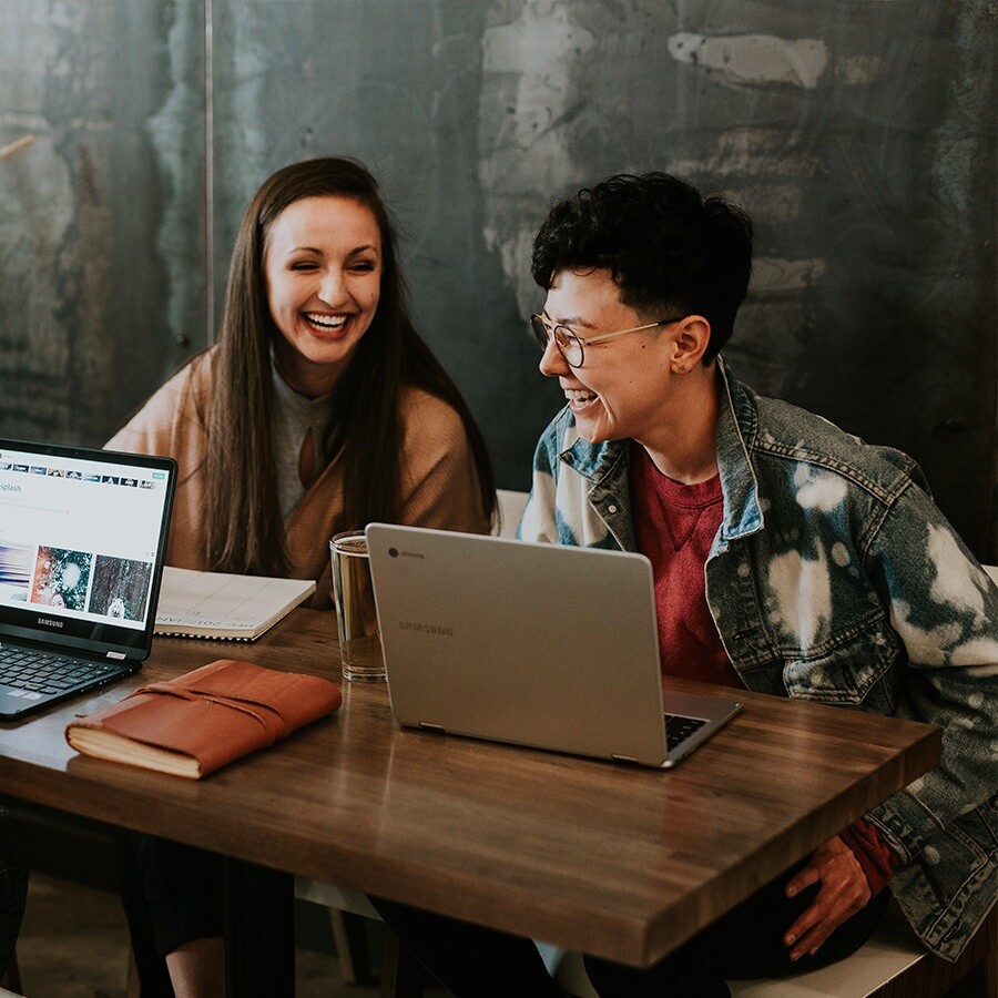 Man and woman in a cafe using computers